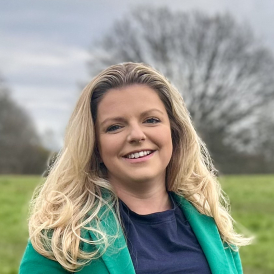 Head shot of Hannah Campbell in a green suit. 