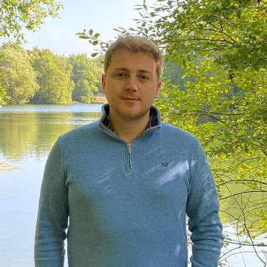 Tom Wust standing in front of a lake.