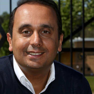 Head shot of Paul Uppal in front of railings.